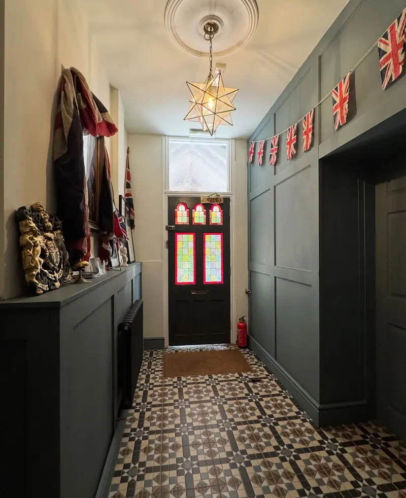 Period hallway with a patterned tiled floor, panelled walls and a stained glass front door