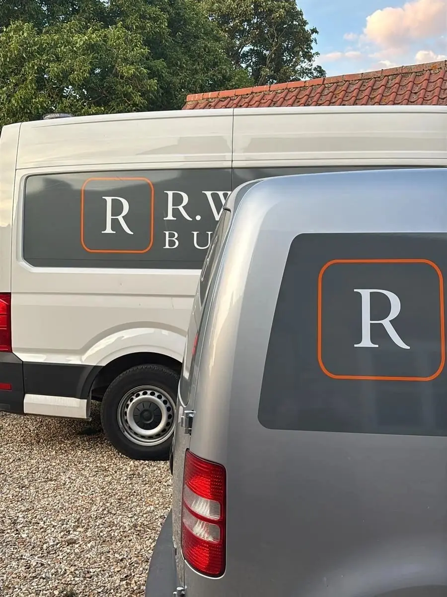 Two R Wakefield Building vans in grey and white livery with the firm’s R logo